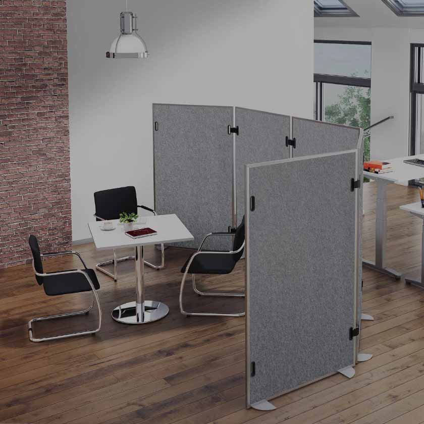 Büroausschnitt in dem eine Sitzecke mit einer Akustiktrennwand vom Rest des Raumes abgetrennt ist