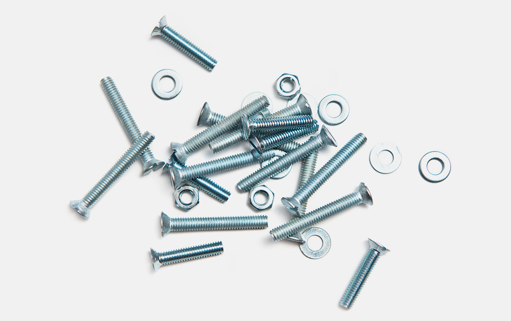 Draufsicht auf ein kleines Sortiment von Senkkopf-, Gewindeschrauben unterschiedlicher Längen mit dazugehörigen Unterlegscheben