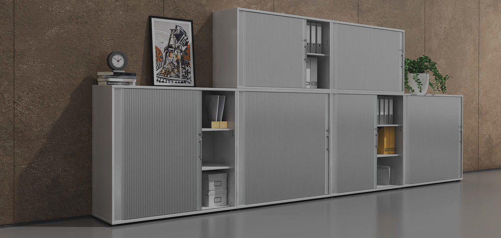 Wandausschnitt vor dem eine moderne Rolladenschrankwand in hellem Grau steht