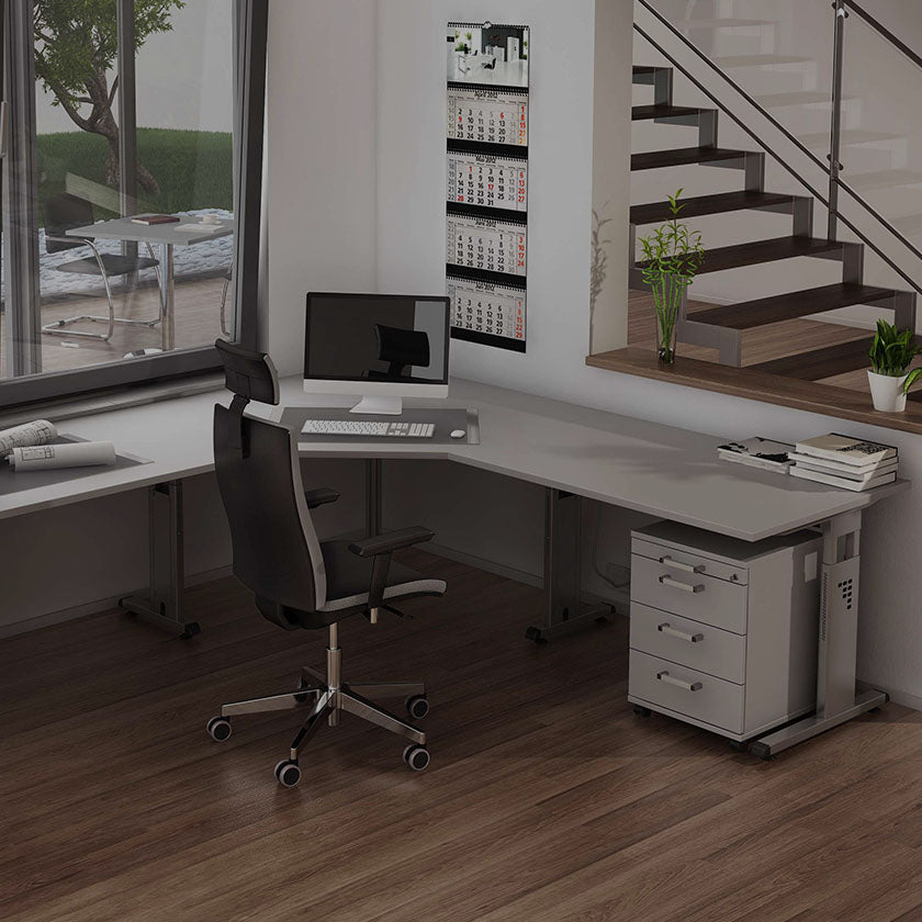 Arbeitsplatz in einem modernen Büro der über Eck geht und an dem ein Bürostuhl steht