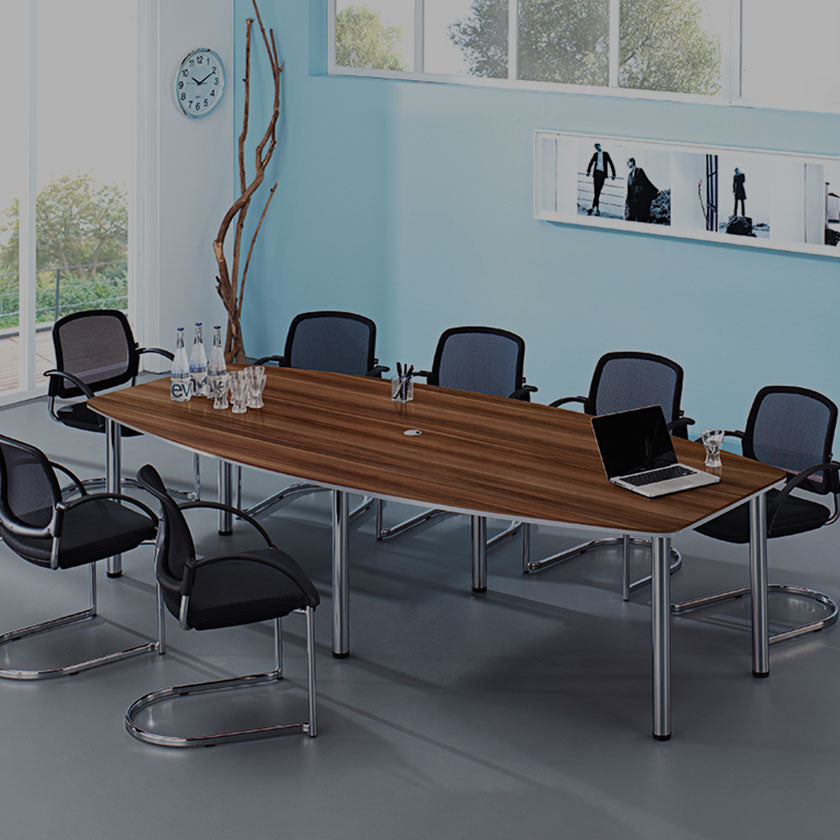 Blick in einen modernen Besprechungsraum mit großem Tisch in Nussbaum und Chrom, um den Besprechungsstühle in Schwarz und Chrom stehen