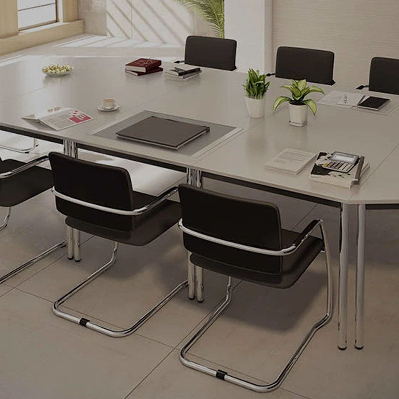 Blick auf einen hellen Besprechungstisch mit Büroutensilien und Besprechungsstühlen drum herum